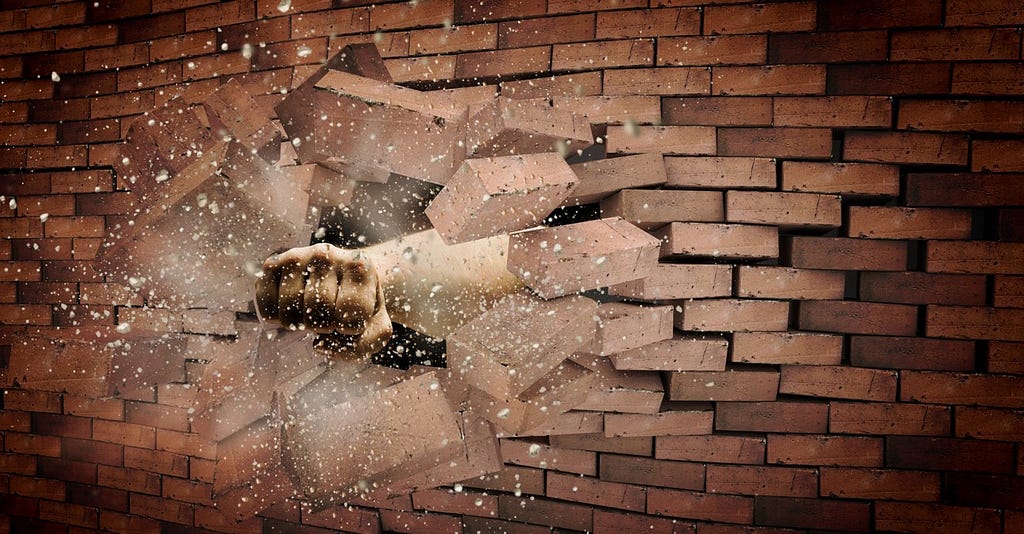Fist breaking through an illustrated brick wall
