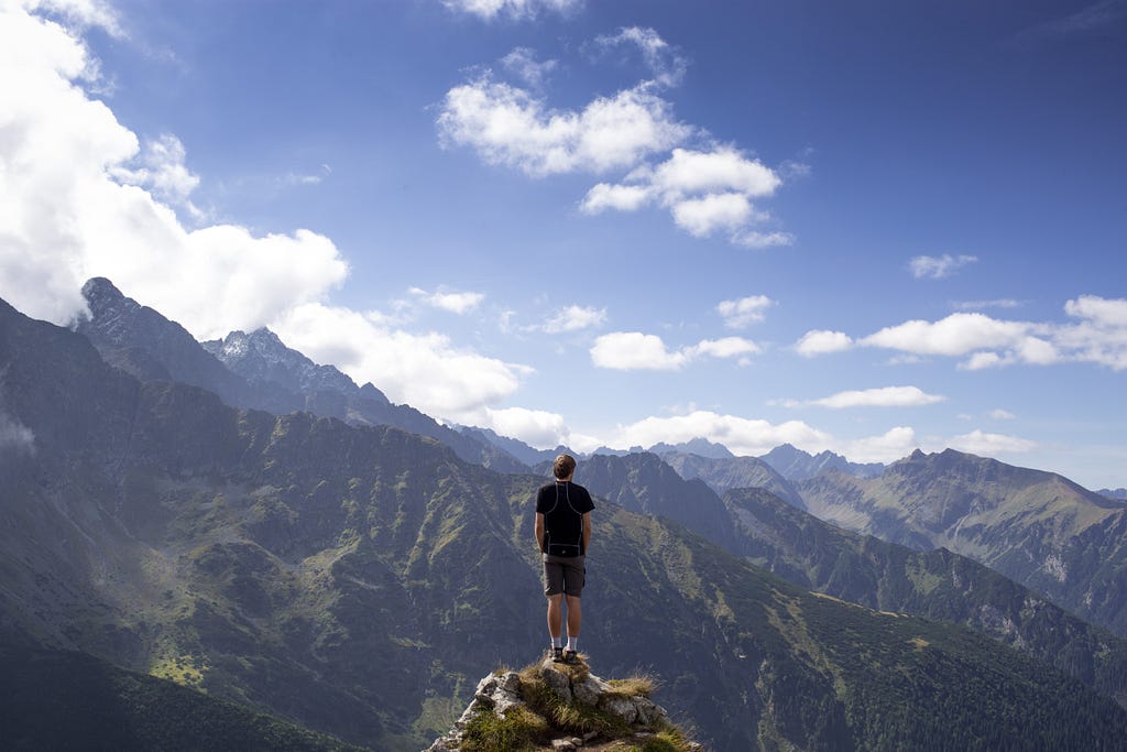 Person standing on a mountain viewpoint